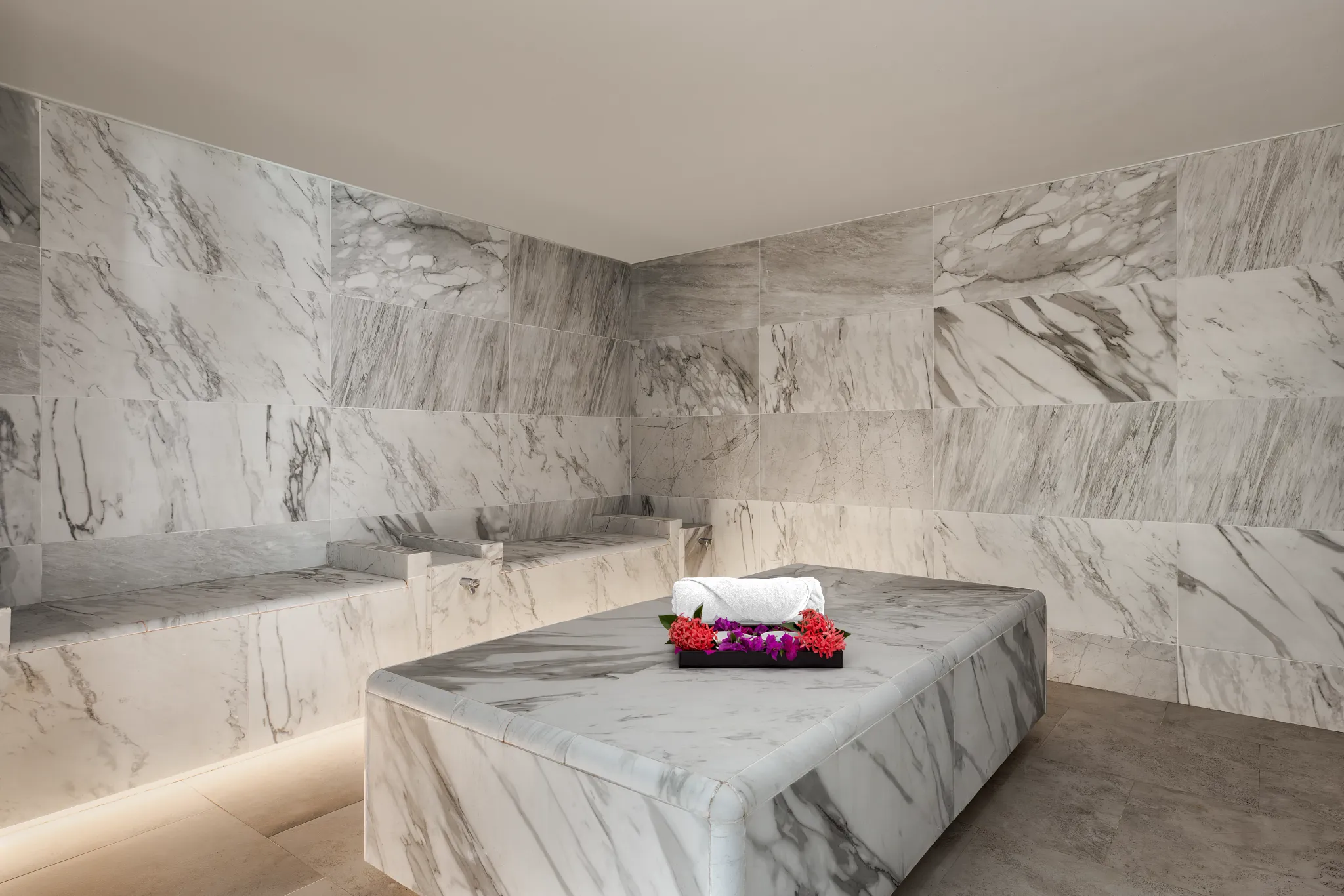 Marble hammam steam room at Secrets St. Lucia Resort & Spa, featuring heated stone seating for a luxurious spa ritual.