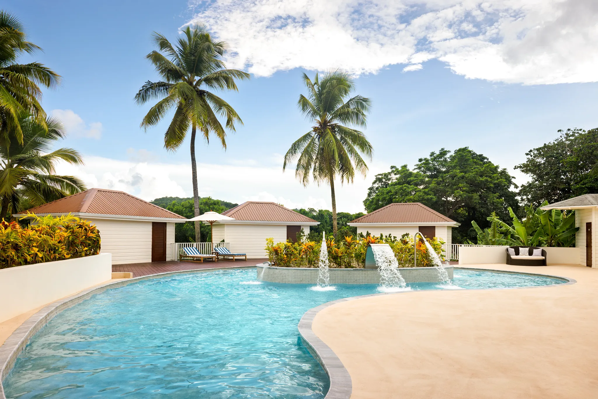 Tropical hydrotherapy pool with water features at Secrets St. Lucia Resort & Spa, surrounded by palm trees and private cabanas.